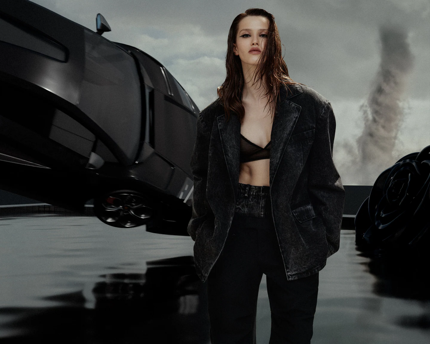 Model in black beside a futuristic spacecraft